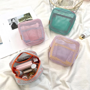 Detailed view of colorful mesh makeup bags organizing lipsticks and skincare bottles