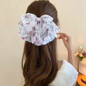 Elegante molletta fiocco in chiffon bianco con stampa floreale su capelli mossi