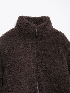 Close-up of brown fleece jacket showing textured lamb wool fabric and metal zipper detail