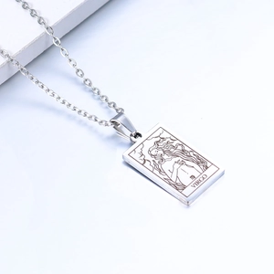 Macro detail of Virgo zodiac pendant in silver finish on a minimalist white prop