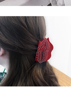 Détail de la pince à cheveux en forme de lèvres rouges avec strass scintillants
