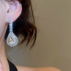 Detailed view of silver teardrop earrings with crystals worn by a model for elegant look