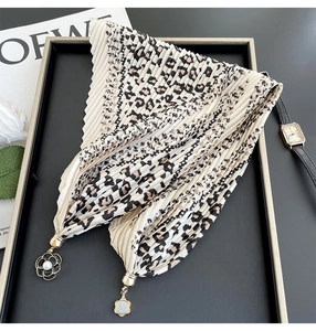 Detail of leopard print pleated silk scarf with pearl and gold metal flower charms