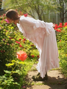 Pink V-neck ruffle dress with irregular split hem in a romantic rose garden setting