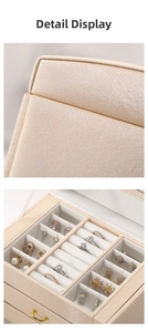 Detail view of cream PU leather jewelry box with ring slots and soft velvet lining