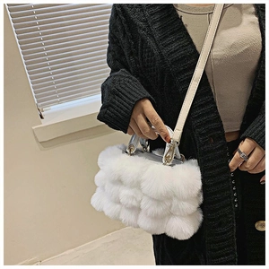 Close-up of white faux fur handbag with round handle and adjustable PU leather strap