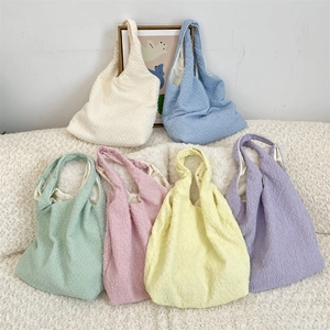 Close-up of pleated tote bags in six pastel colors showing bubbly fabric texture