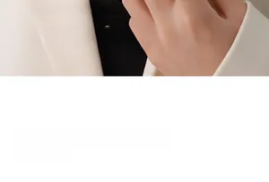 Close-up of minimalist gold ring worn on index finger with professional white suit