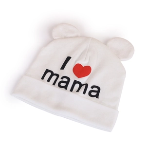 Detailed texture of white knit baby bear hat with red I Love Mama logo and ears