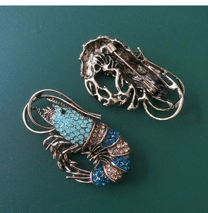 Detailed macro view showing the front and back of a vintage crystal lobster brooch