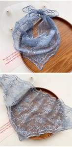 Close-up of light blue floral lace scarf with embroidery and breathable mesh texture