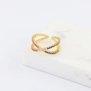 Detail of gold criss-cross open ring with colorful zircon stones on marble stand