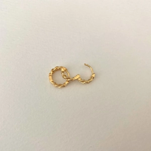 Macro detail of 925 silver chain link hoop earrings in a polished golden finish