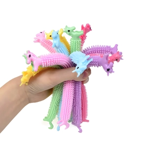 Hand holding colorful unicorn stretch fidget toys in pink, blue, yellow and purple