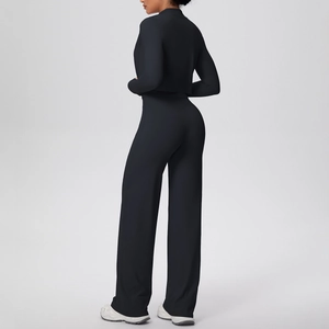 Vue arrière de l'ensemble de yoga noir 3 pièces avec veste zippée et pantalon large fluide