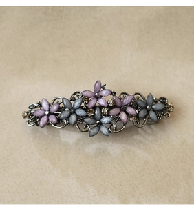 Detailed view of vintage alloy hair clip with purple and grey rhinestone flowers