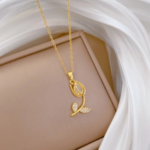 Golden tulip necklace with white cat eye stone and zircon crystals on beige leather case