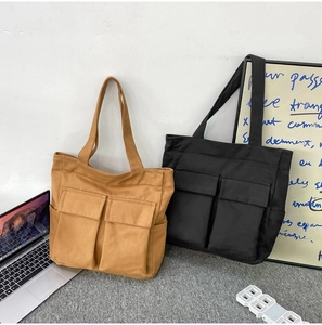 Detail showing brown and black canvas tote bags with spacious dual front pockets