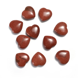 Macro shot of 20mm heart-shaped red goldstone crystals with sparkling golden specks