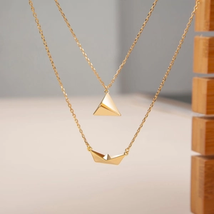 Minimalist gold origami plane and boat layered necklaces with elegant metallic finish