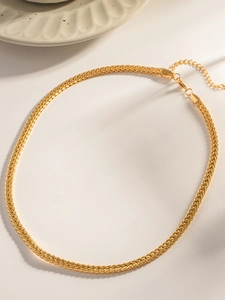 Dettaglio della collana a trama intrecciata dorata con chiusura a moschettone regolabile