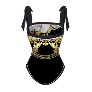 Détail de l'imprimé baroque doré et des bretelles à nœuds sur le maillot une pièce