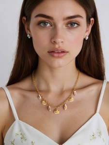 Close-up of 18k gold plated shell pendant necklace and floral earrings on model