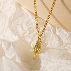 Detailed close-up of a 18k gold plated necklace featuring a realistic hand gesture pendant