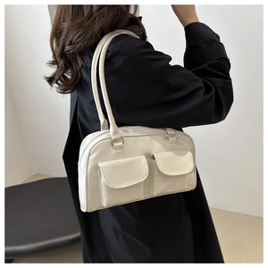 Detail of cream white retro shoulder bag featuring two functional front pockets and slim straps