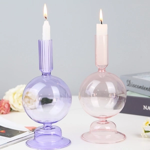 Elegant purple and pink glass candle holders with vertical stripes and burning candles