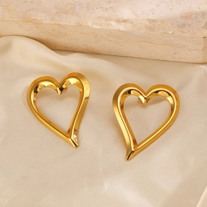 Golden hollow heart-shaped C-stud earrings placed on elegant beige silk and stone