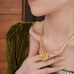 Detail of vintage gold necklace with amber gemstone and crystals on velvet