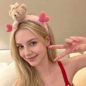 Detailed view of a sweet pink plush headband featuring a cute brown bear and hearts