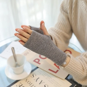 Detail of grey knitted fingerless gloves showing thumb holes and ribbed texture cuffs