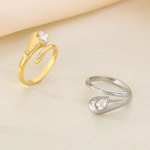 Minimalist 18k gold and silver snake rings with diamond-encrusted heads on beige fabric