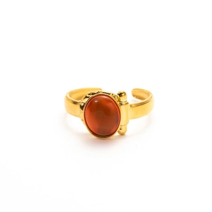 Macro shot of an adjustable gold ring with a polished oval amber natural stone