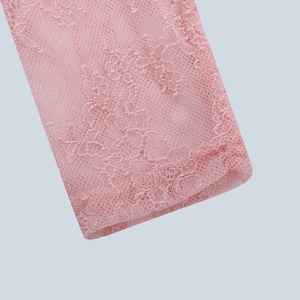 Close-up of pink lace fabric showing intricate floral patterns and mesh detailing