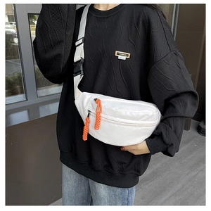 Close-up of white canvas chest bag featuring vibrant orange zipper pulls and adjustable strap