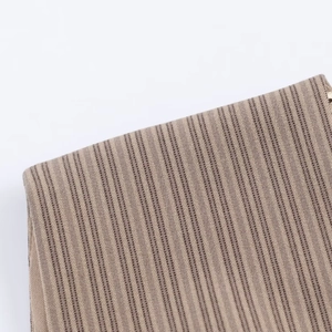 Vue détaillée des rayures verticales sur une robe d'été en tricot beige et marron