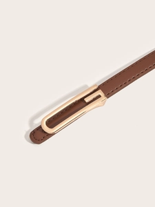 Detail of a brown leather belt with a minimalist golden rectangular metal buckle and stitching