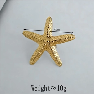Detail of 48mm golden starfish jewelry showing metal texture and dimension