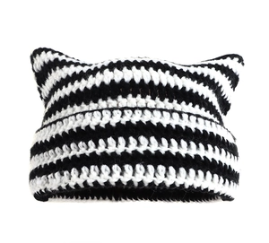 Detailed knit texture of a black and white striped cat ear beanie hat with soft yarn