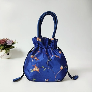 Detailed embroidery on blue satin drawstring bucket bag with floral pattern