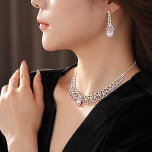 Detail of luxury teardrop jewelry set featuring pink crystal stones and silver plating