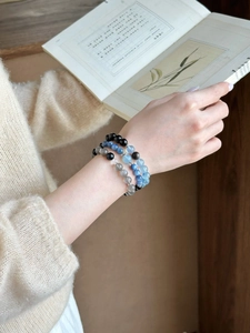 Three-layered natural moonstone and obsidian beaded bracelets on a woman's wrist