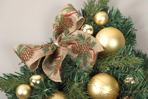 Detail eines Weihnachtsanhängers mit goldenen Kugeln und bedruckter Leinenschleife