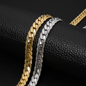 Detailed close-up of gold and silver textured Cuban link chains on black leather