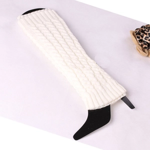 Detail of white cable knit leg warmers showing thick braided pattern and soft texture