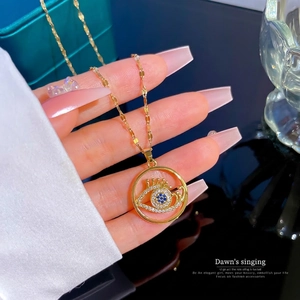 Gold-plated evil eye necklace with blue and white zircon stones on a wavy chain