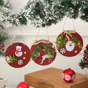 Set of three buffalo plaid wooden Christmas ornaments hanging from a pine branch